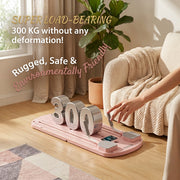 A pink floor scale with large silver numbers reading 300 is shown in a bright living room. A person's hand is touching the handle, and promotional text says 'SUPER LOAD-BEARING 300 KG without any deformation! Rugged, Safe & Environmentally Friendly.